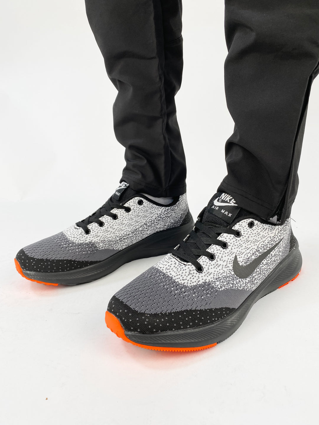 Nike air max trainers in black and white spots with orange soles
